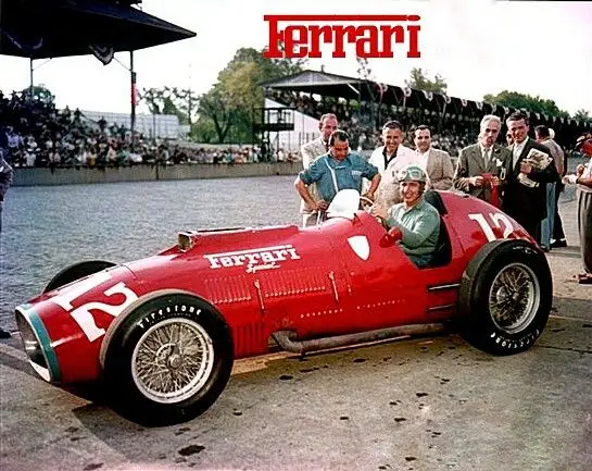 Vintage Ferrari race car with driver and crew at a racetrack, showcasing classic design and automotive heritage.