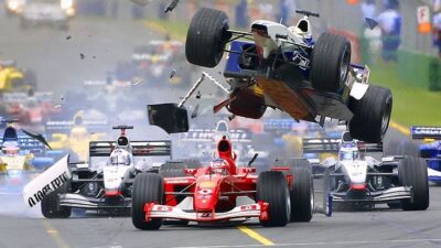 Formula 1 race crash with cars in collision, dynamic action scene on track, debris flying in high-speed motorsport event.
