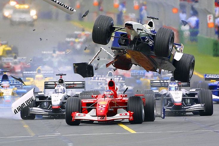 Formula 1 race crash with cars in collision, dynamic action scene on track, debris flying in high-speed motorsport event.