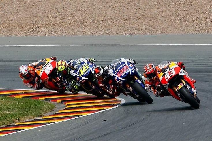 Motorcycle racers leaning into a sharp curve on the track during a competitive race, showcasing speed and precision.