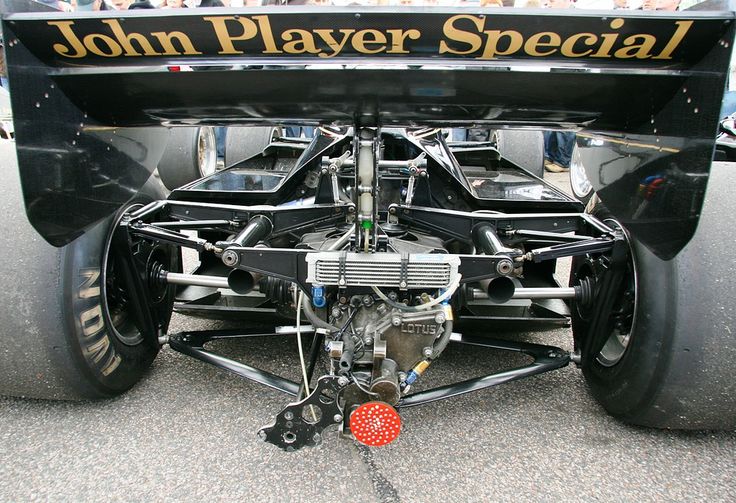 Rear view of a vintage race car displaying the John Player Special livery and intricate mechanical details.