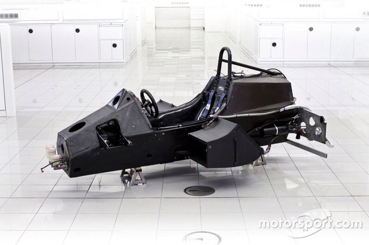 Mclaren MP4_1 monocoque - Engine Stories Formula One car chassis in workshop, showcasing sleek design and precision engineering. Perfect for motorsport enthusiasts and engineers.