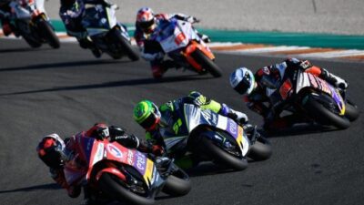 Motorcycle racers speeding on a track, competing closely in a thrilling race.