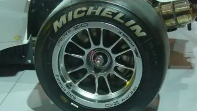 Close-up of a Michelin racing tire on a Formula BMW car, featuring OZ Racing wheels, showcasing high-performance auto design.