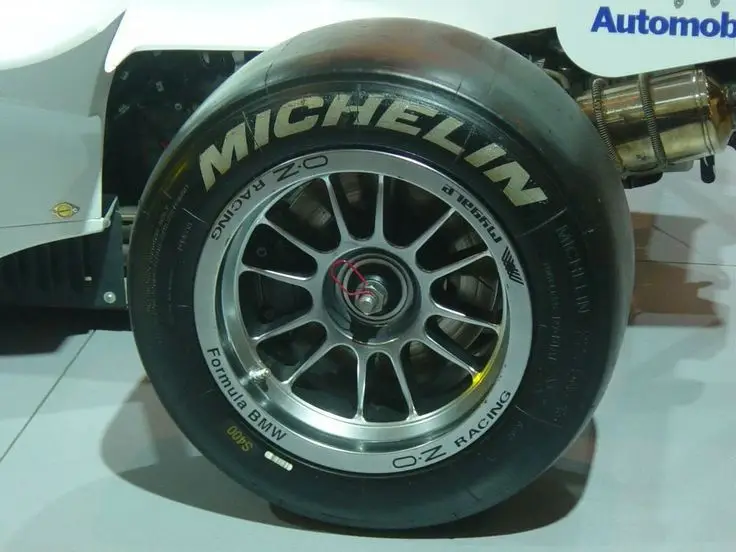Close-up of a Michelin racing tire on a Formula BMW car, featuring OZ Racing wheels, showcasing high-performance auto design.