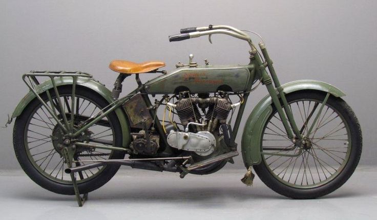 Vintage green motorcycle with leather seat and V-twin engine, showcasing classic design and retro charm.