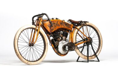 Vintage Flying Merkel motorcycle with orange frame and white tires on display. Classic design highlights early 20th-century engineering.