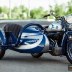 Motorworld - Engine Stories Vintage blue motorcycle with sidecar, 1931 model O.D. T100 from Germany, showcased on a road, classic design and retro style.